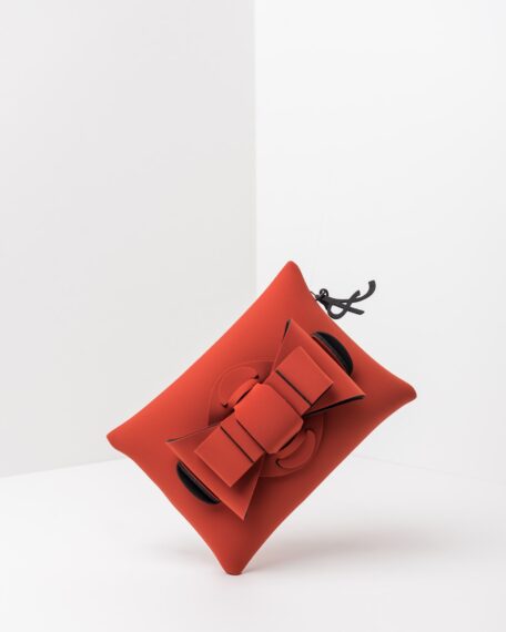 La foto ritrae una borsa modello pochette della linea Chérie di APbag. Si tratta di una borsa lavabile effetto neoprene, disegnata da Stefano Galandrini, prodotta e distribuita da Artpelle.it La borsa è di colore cotto.