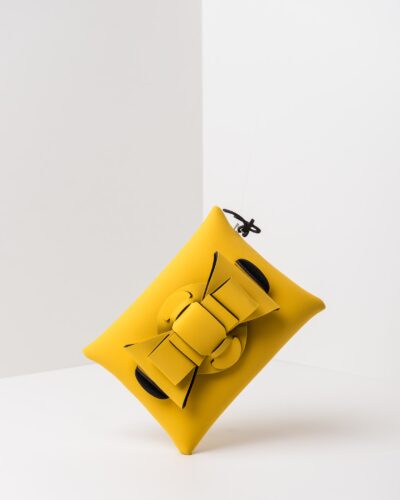 La foto ritrae una borsa modello pochette della linea Chérie di APbag. Si tratta di una borsa lavabile effetto neoprene, disegnata da Stefano Galandrini, prodotta e distribuita da Artpelle.it La borsa è di colore giallo.