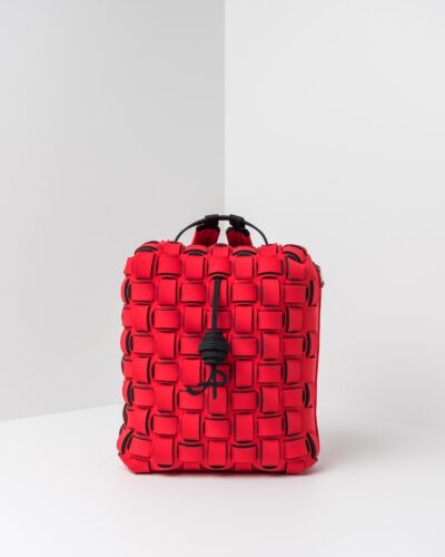 La foto ritrae uno zaino con lavorazione a trama intrecciata della linea Madison di APbag. Si tratta di una borsa lavabile effetto neoprene disegnata da Stefano Galandrini, prodotta e distribuita da Artpelle.it Lo zaino è di colore rosso.
